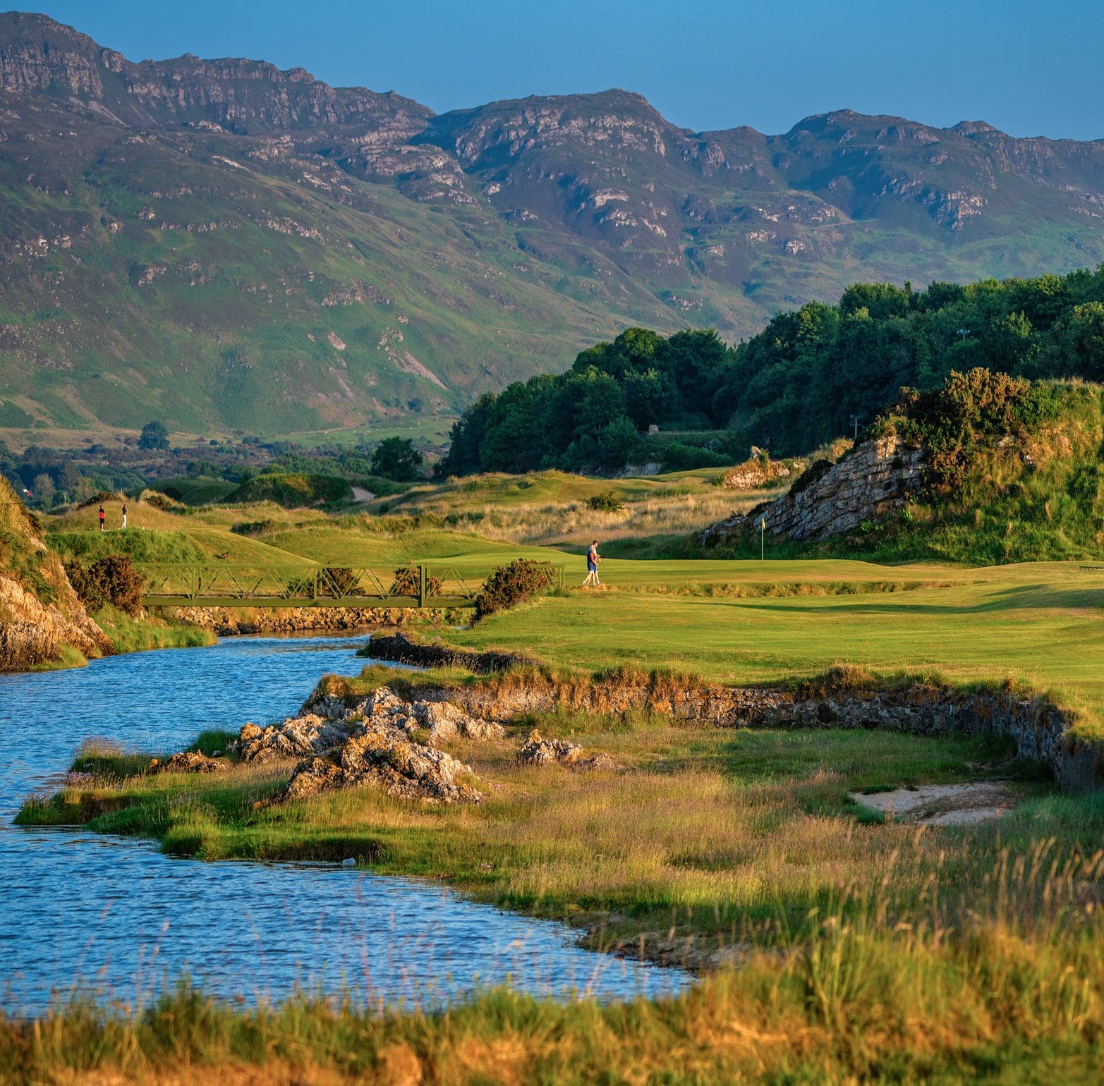 Aerial view of Portsalon Golf Club with golfers walking across a foot bridge.