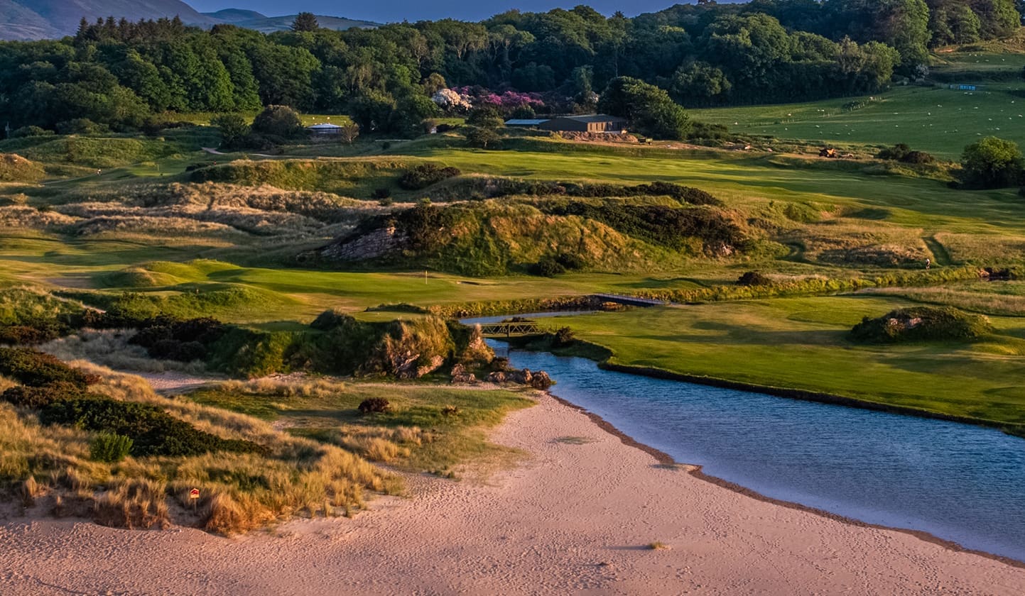 Aerial view of Portsalon Golf Club the green in the background over a small river inlet.